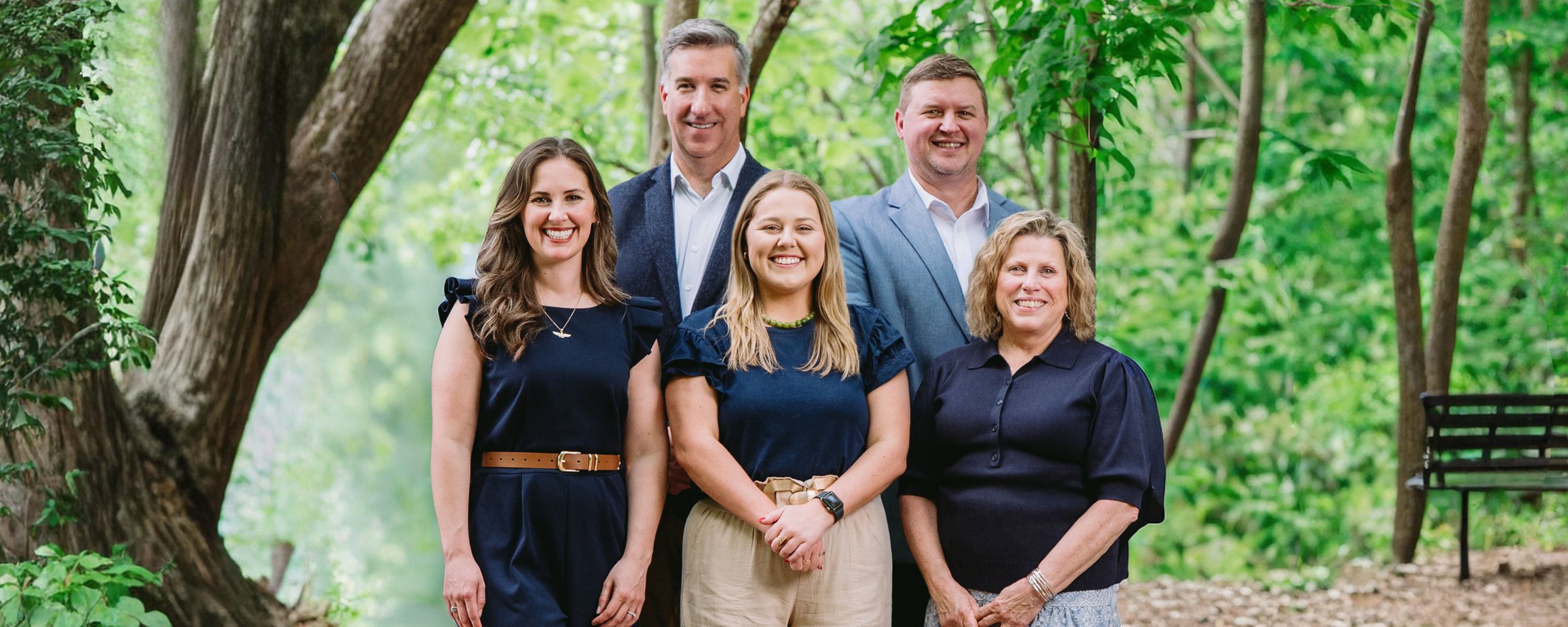 The Cypress Bay Wealth team standing together among the trees